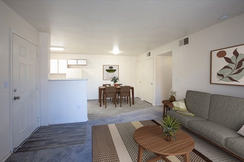 a living room and kitchen with a couch and a table